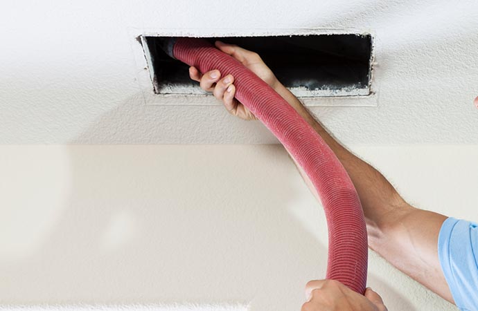 Professional worker sanitizing air duct