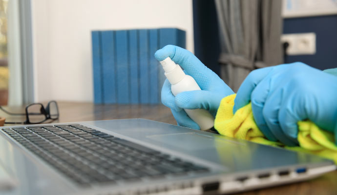 A person cleaning laptop with equipment