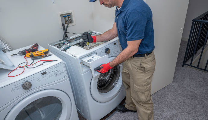 A person repairing a washing machine