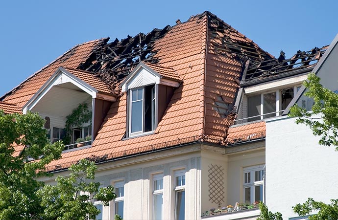 a white building with a fire damaged roof