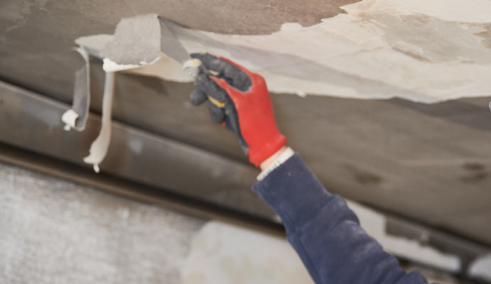 A worker removing soot from the ceiling