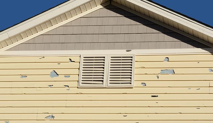 Hail damage on house siding House exterior with visible hail damage on siding