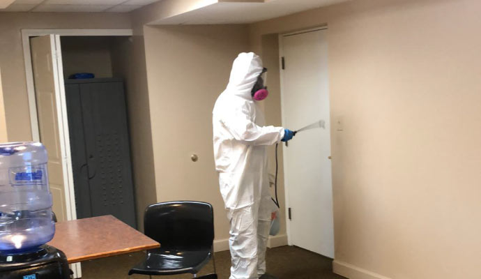 Professional disinfecting a room