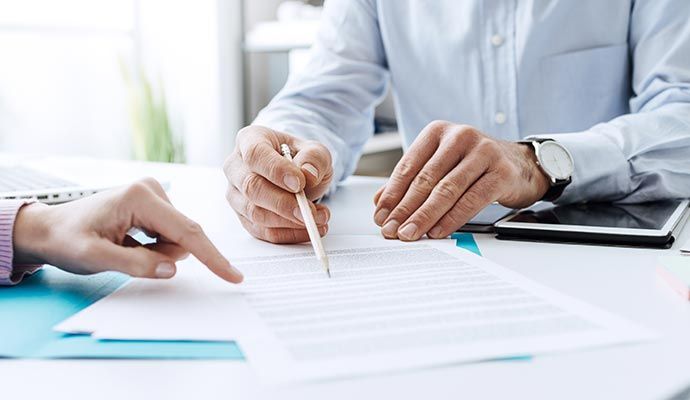 Insurance document review session between assistant and client Professional meeting between assistant and client over insurance paperwork