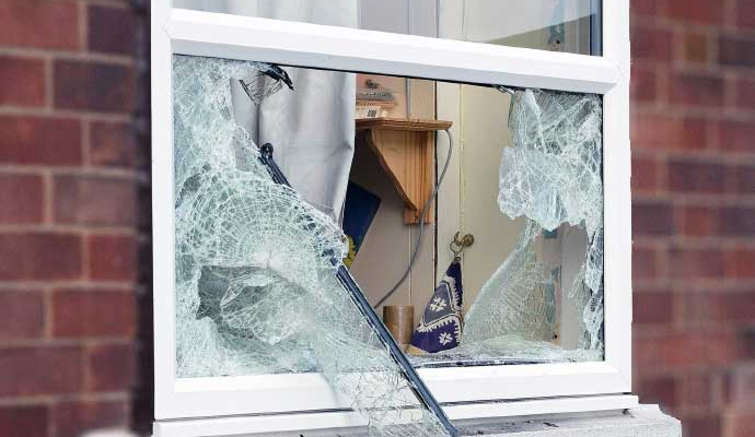 Broken window with shattered glass Broken and shattered window glass on home property