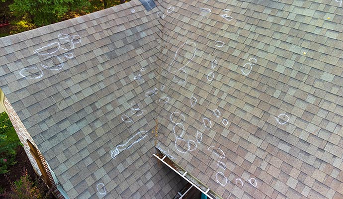 Hail-damaged roof highlighted with white circles Hail-damaged roof highlighted with white circles