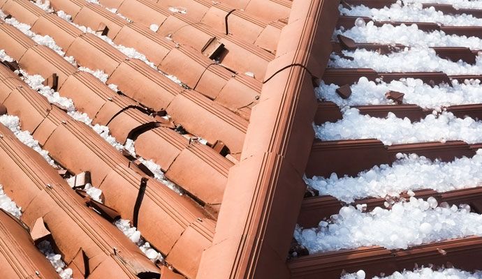 Hail-damaged roof showing cracks and hailstones Roof with visible cracks and hailstones after severe hailstorm damage